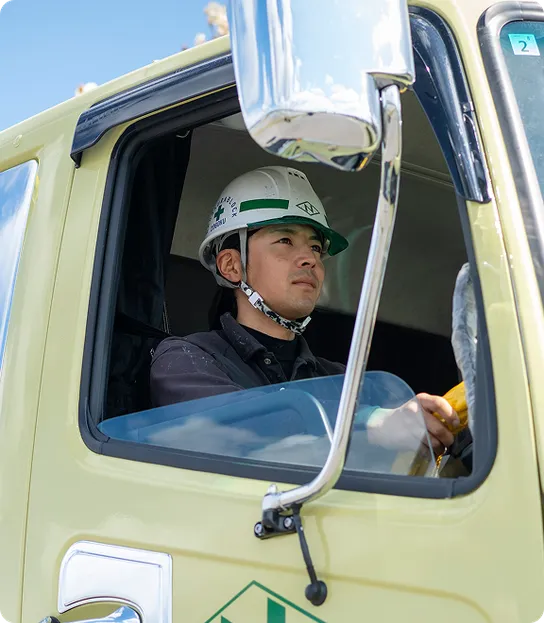 安全装備を着用した男性が建設車両を運転中のようす